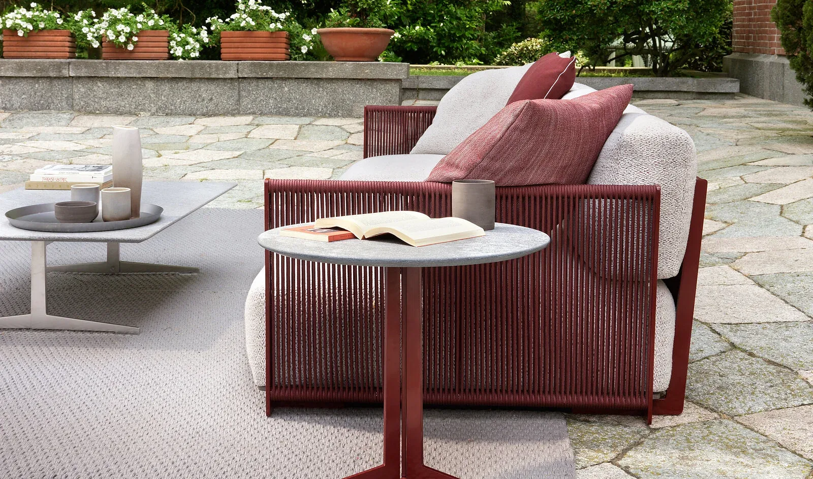 Flexform Fly outdoor coffee table in a garden setting, frame 1